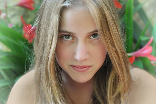 花の背景の美しい十代の少女 — ストック写真