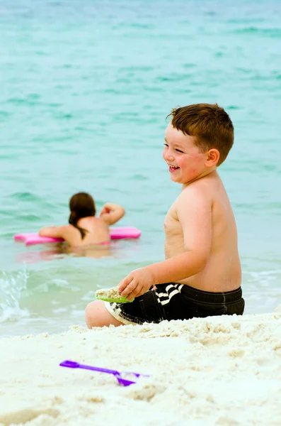 Enfant jouant dans le sable à la plage — Photo