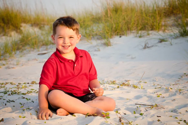 Portrét šťastné dítě na pláž s písečnými dunami v pozadí — Stock fotografie