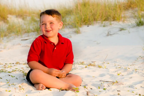 Portret van gelukkig kind op strand met zandduinen op achtergrond — Stockfoto
