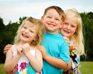 Portrait of three children playing at park clipart