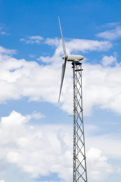 Zijaanzicht van industriële windturbine onder bewolkte blauwe hemel — Stockfoto