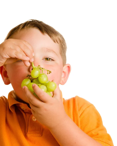 Gezond eten concept met kind geïsoleerd op witte druiven eten — Stockfoto