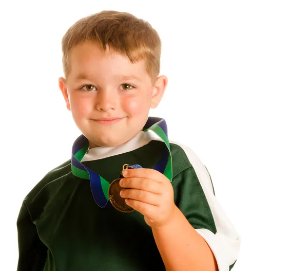 Happy child in soccer or football uniform with medal isolated on white — Stock Photo, Image