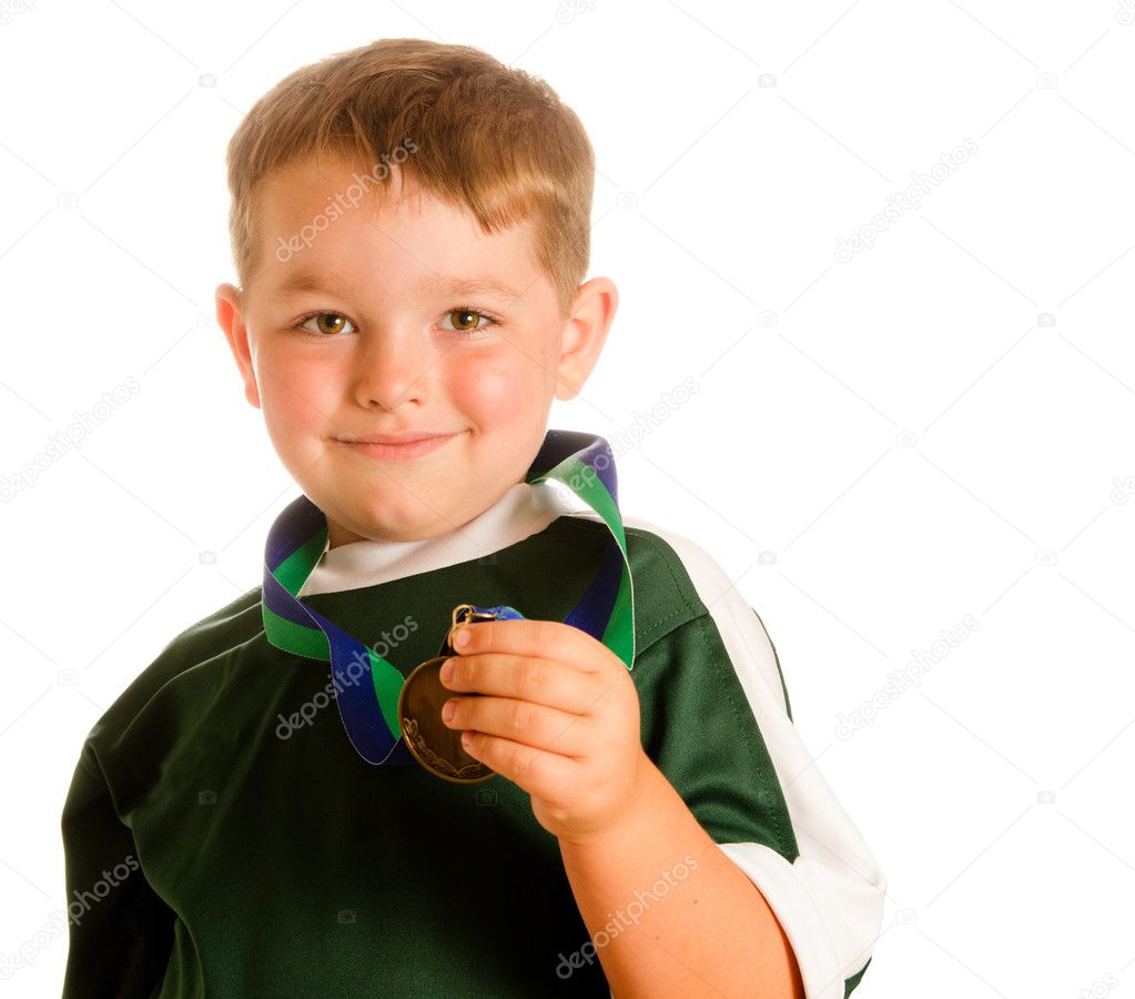 Happy child in soccer or football uniform with medal isolated on white
