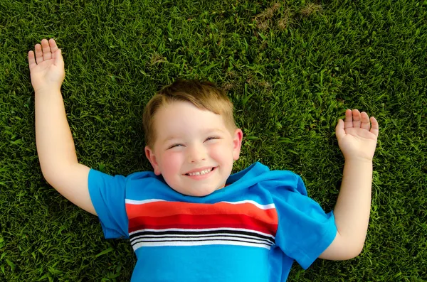Retrato de verano de un niño feliz jugando en la hierba — Foto de Stock