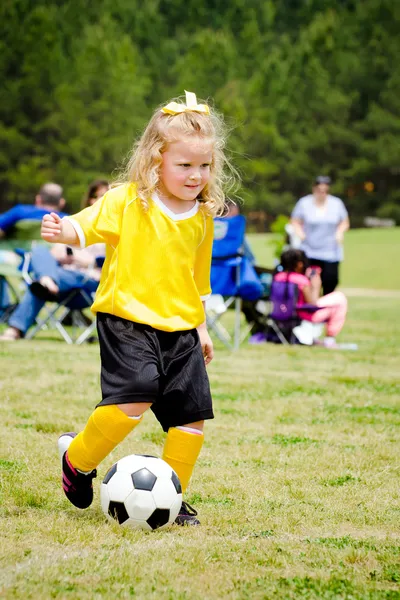 Carino ragazza in uniforme che gioca nella partita di calcio organizzata della lega giovanile — Foto Stock