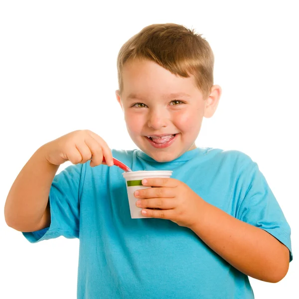 Young child eating yogurt isolated on white — Stock Photo, Image