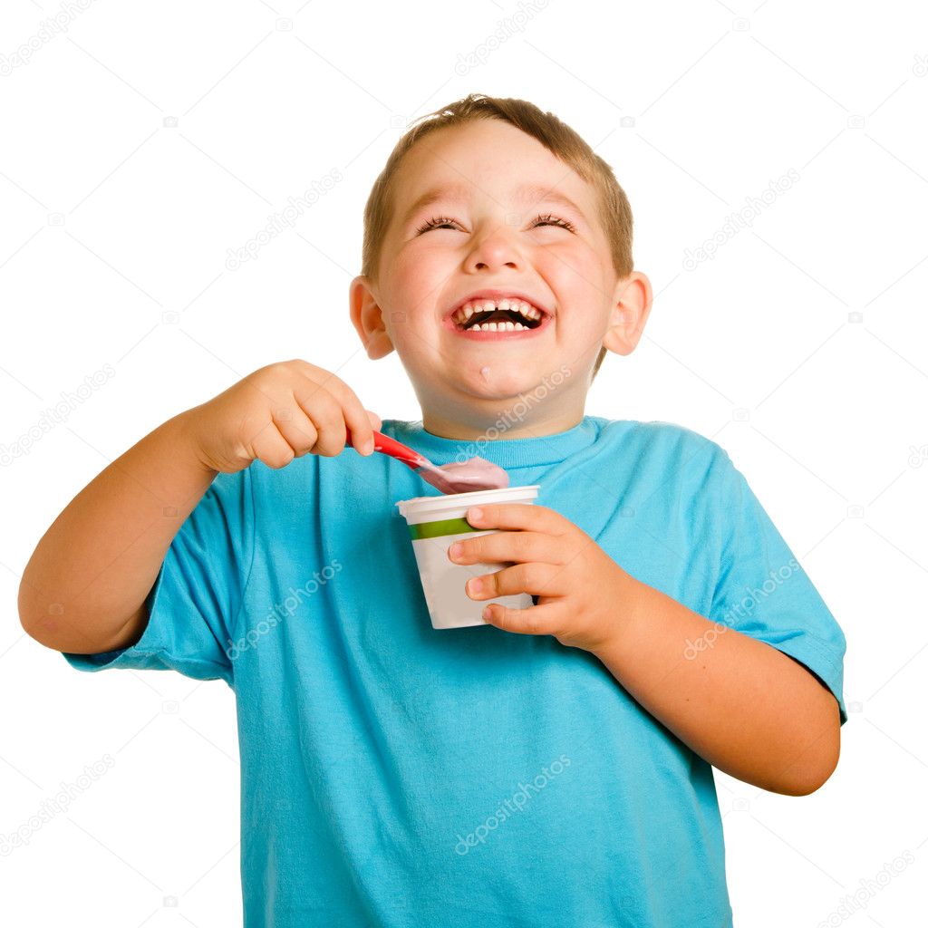 Young child eating yogurt isolated on white