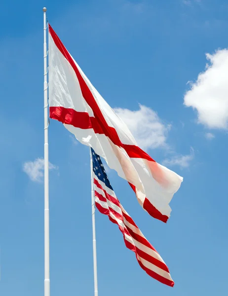 Alabama state flag and U.S. flag together under cloudy blue sky — Stock Photo, Image