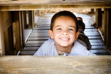 Young african-american child eating healthy snack while playing on playground clipart