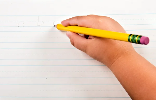 Utbildning tillbaka till skolan koncept med närbild på barnets hand skriva alfabetet på papper — Stockfoto