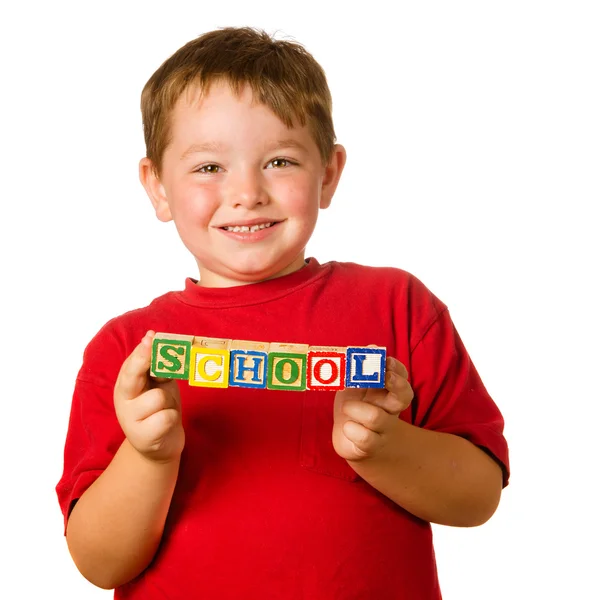 Preschool education concept with child holding blocks that spell out "school" — Stock Photo, Image