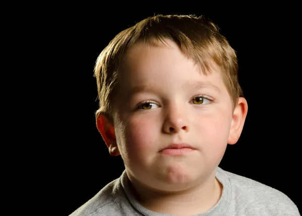 Портрет серьезного, грустного, злого или подавленного ребенка, изолированного на черном — стоковое фото