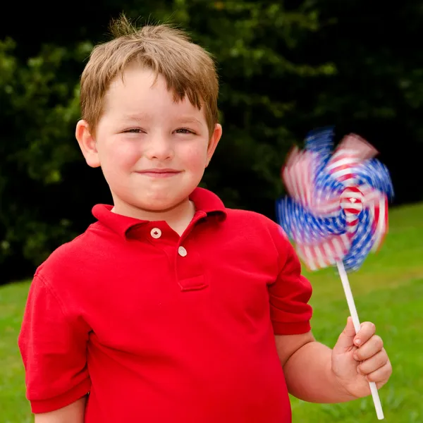 Niño jugando con el molinete de la bandera estadounidense para celebrar el Día de la Independencia el 4 de julio —  Fotos de Stock