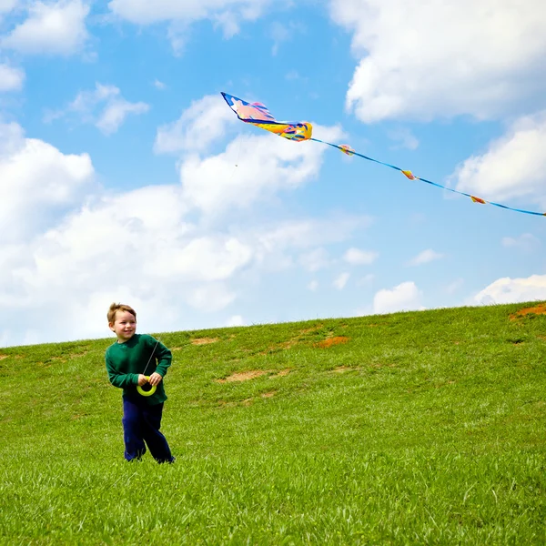 Child flying kite and playing outdoors at park — Stock Photo, Image