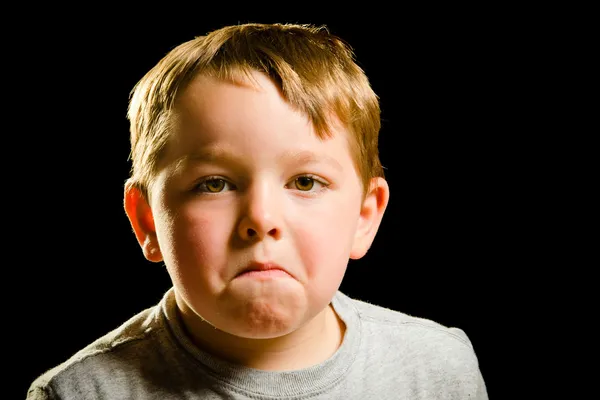 Portrait of serious, sad, angry or depressed child isolated on black — Stock Photo, Image