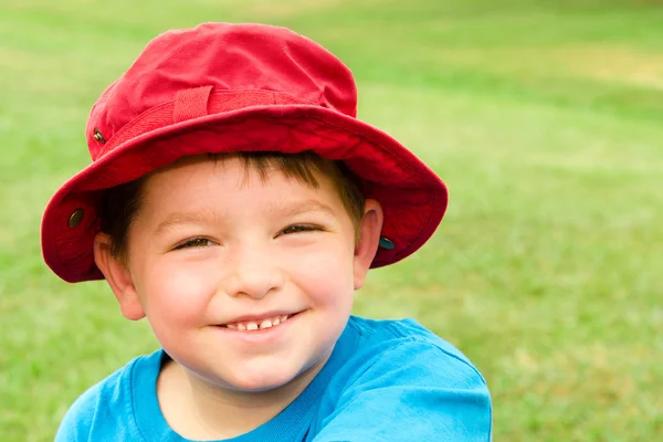 Yaz portre parlak kırmızı şapka, açık havada park giyen çocuk — Stok fotoğraf