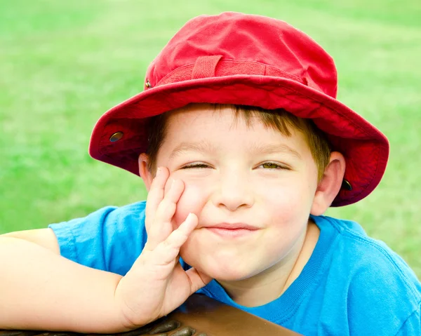 Criança em retrato de verão vestindo chapéu vermelho brilhante ao ar livre no parque — Fotografia de Stock
