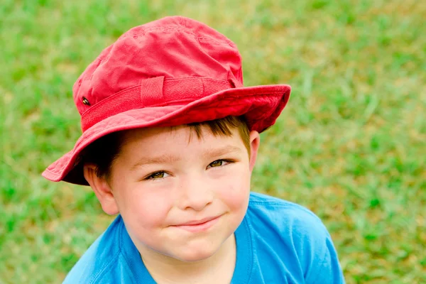 Criança em retrato de verão vestindo chapéu vermelho brilhante ao ar livre no parque — Fotografia de Stock