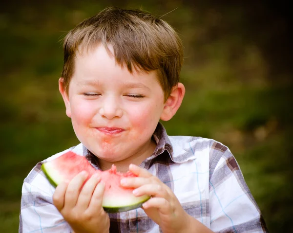 Retrato de verano de un niño pequeño y lindo comiendo sandía al aire libre — Foto de Stock
