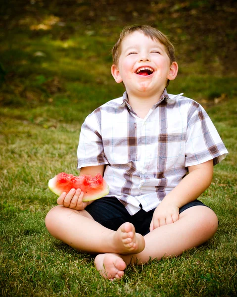Летний портрет милого маленького ребенка, поедающего арбуз на открытом воздухе — стоковое фото