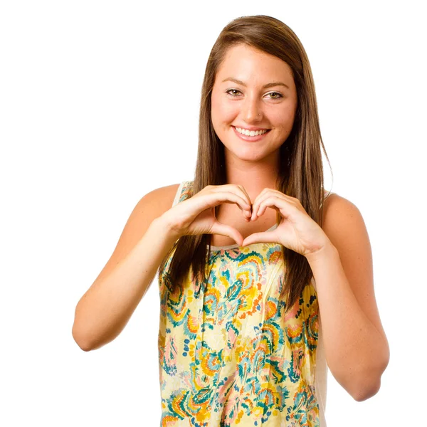Smiling teenager girl making heart shape with her hands isolated on white — Stock Photo, Image