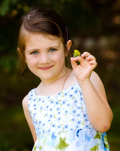 Retrato ao ar livre de menina bonito segurando flor no parque — Fotografia de Stock