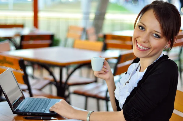 Жінка працює з чашкою кави — стокове фото