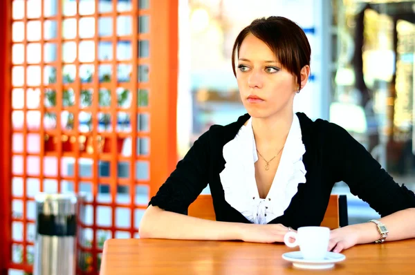 Eenzame brunette bij het café denken over iets triest — Stockfoto