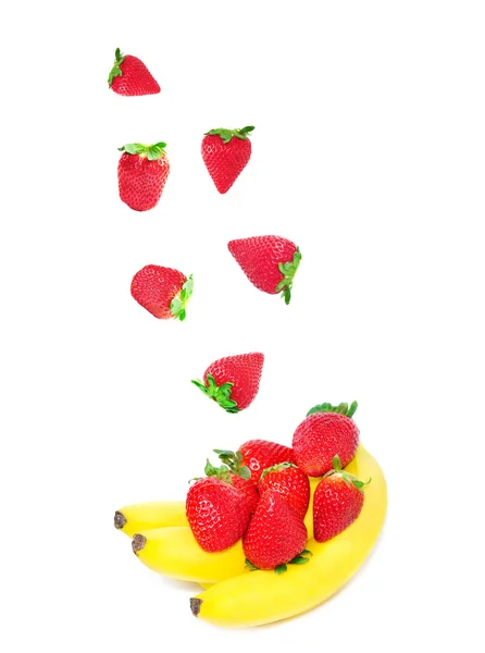 Caída de fresas y plátanos sobre fondo blanco — Foto de Stock