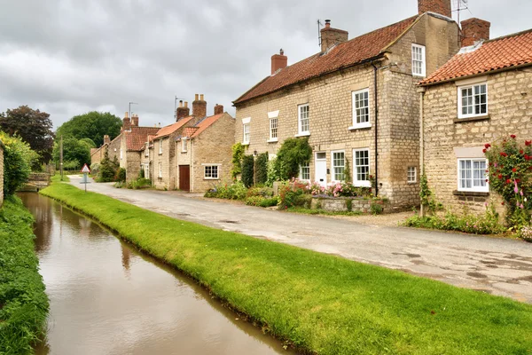 Quaint cottages and stream in an English village — Stock Photo, Image