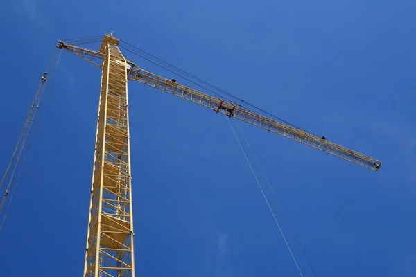 stock image Yellow hoisting crane on blue sky background