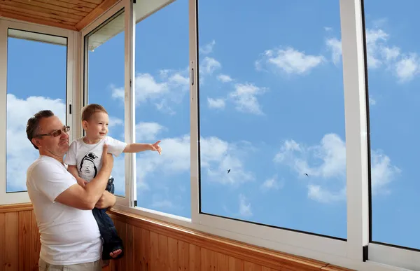 Kleinzoon en grootvader permanent op balkon en kijken naar de — Stockfoto