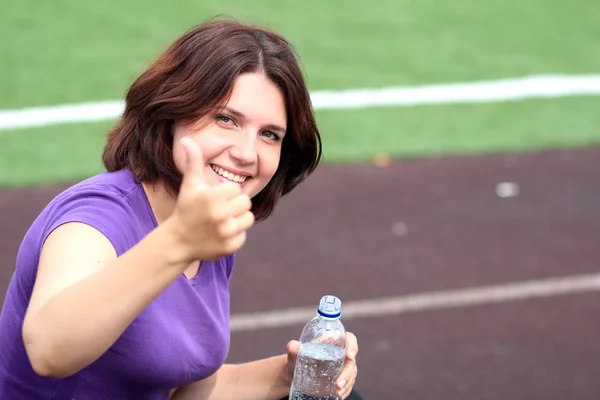 Hermosa mujer de fitness con botella de agua y pulgar hacia arriba — Foto de Stock