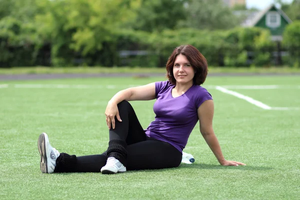 Piękne fitness kobieta siedzi na stadionie — Zdjęcie stockowe