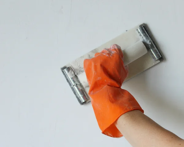 Plasterer smoothing out wall — Stock Photo, Image