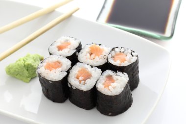 Somon maki sushi yemek çubukları ve beyaz backgro soya sos ile