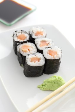 Somon maki sushi yemek çubukları ve beyaz backgro soya sos ile