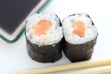 Somon maki sushi yemek çubukları ve beyaz backgro soya sos ile