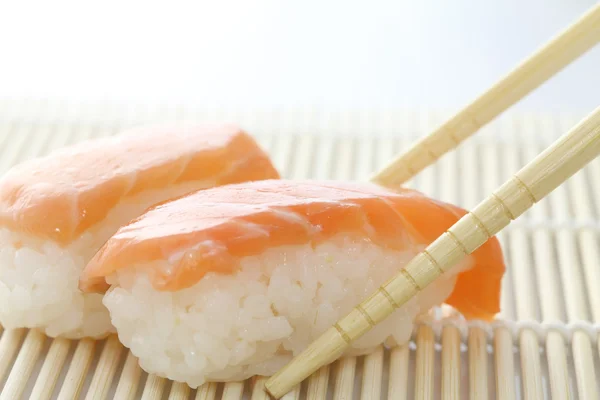 Суши из лосося с палочками — стоковое фото