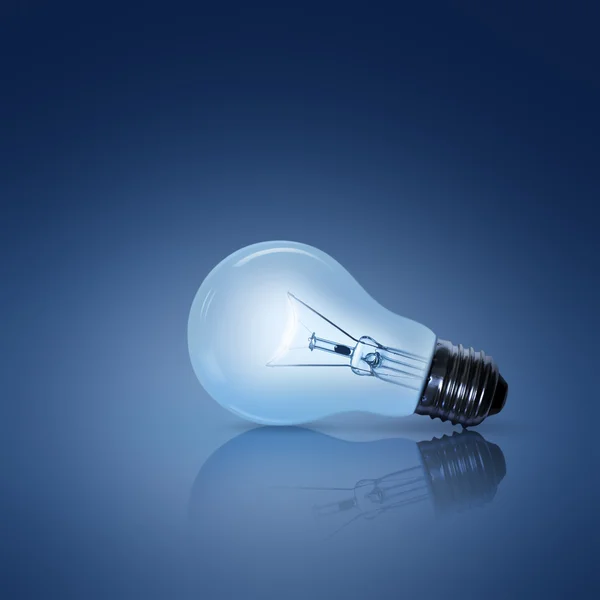 Glühbirne auf blauem Hintergrund lizenzfreie Stockbilder