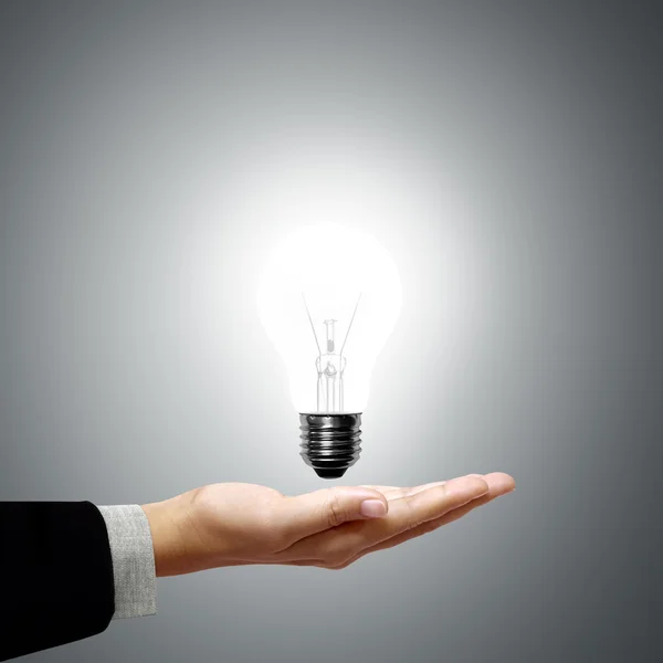 Glühbirne in der Hand Stockbild