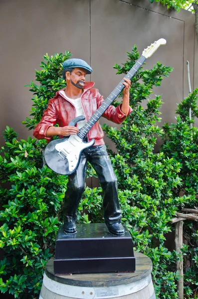 Statue eines Mannes, der eine Gitarre bläst. — Stockfoto