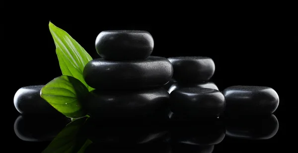 Спа камені і зелене листя на чорному фоні — стокове фото