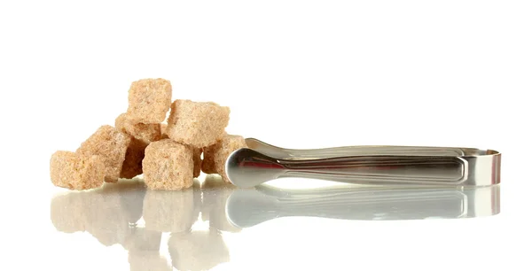 Braune Zuckerrohrwürfel mit Zuckerzange isoliert auf weiß — Stockfoto