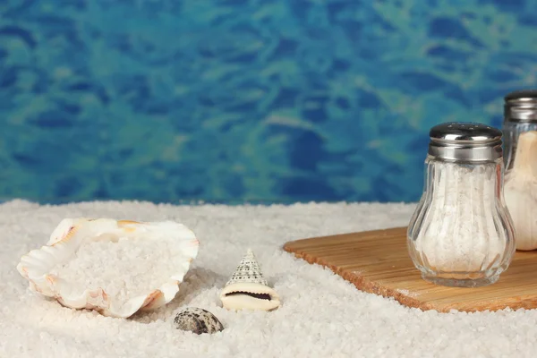 Морская соль на пляже и на разделочной доске на фоне крупного плана — стоковое фото