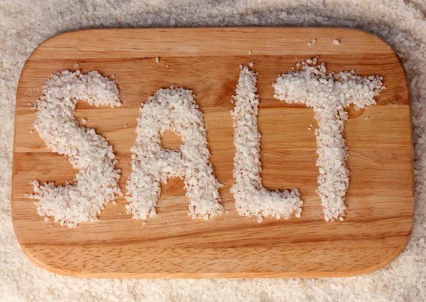 Морская соль на доске для резки крупным планом — стоковое фото