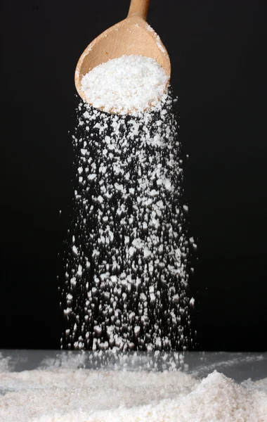 Colher de madeira com sal marinho em um fundo cinza close-up — Fotografia de Stock