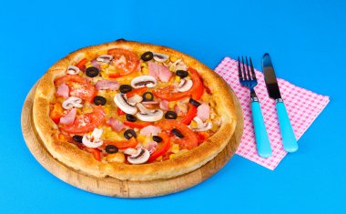 çatal ve bıçak üzerinde mavi arka plan aromatik pizza